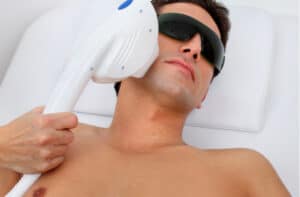 man in laser safety goggles in spa salon