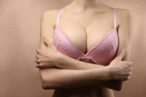 Woman crossing arms with large breast implants